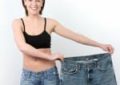 A Fit girl holding her old loose jeans