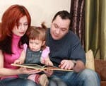 Parents reading book with their baby