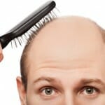 Bald man brushing his hair