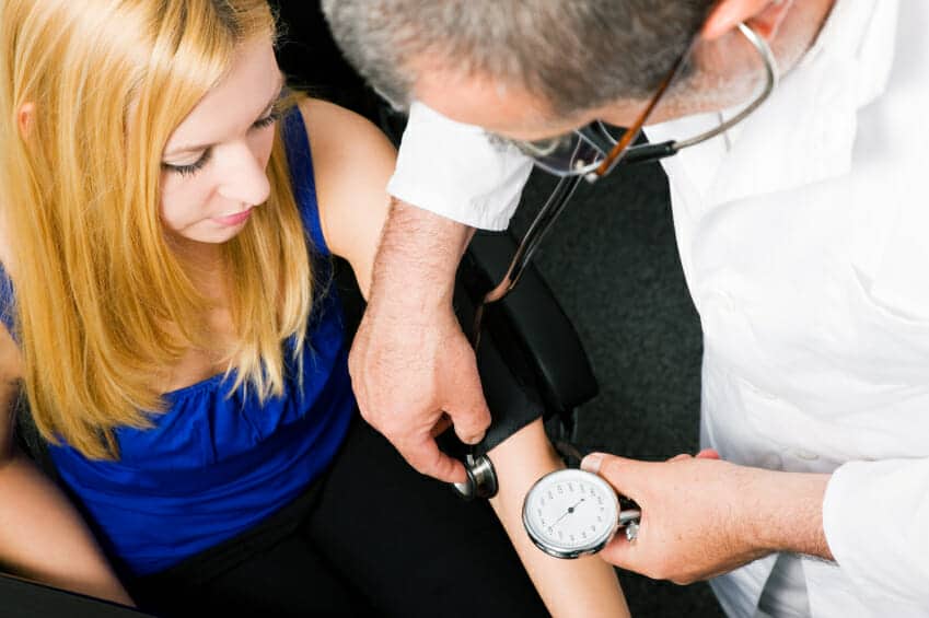 Doctor measuring blood pressure of a lady