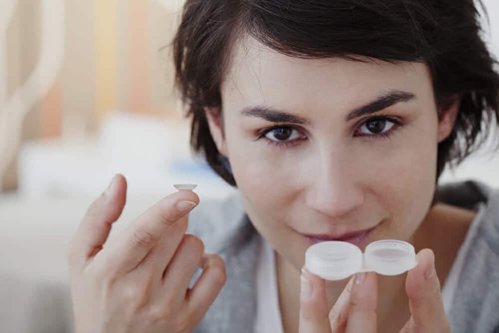 Woman holding contact lens