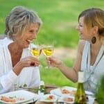Happy mother and daughter having wine