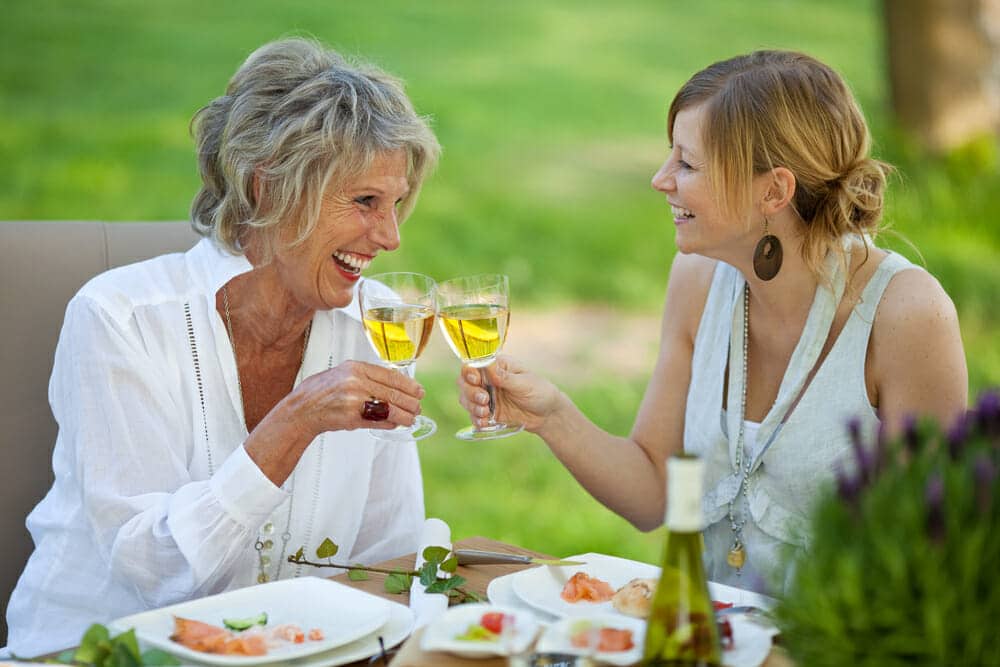Happy mother and daughter having wine