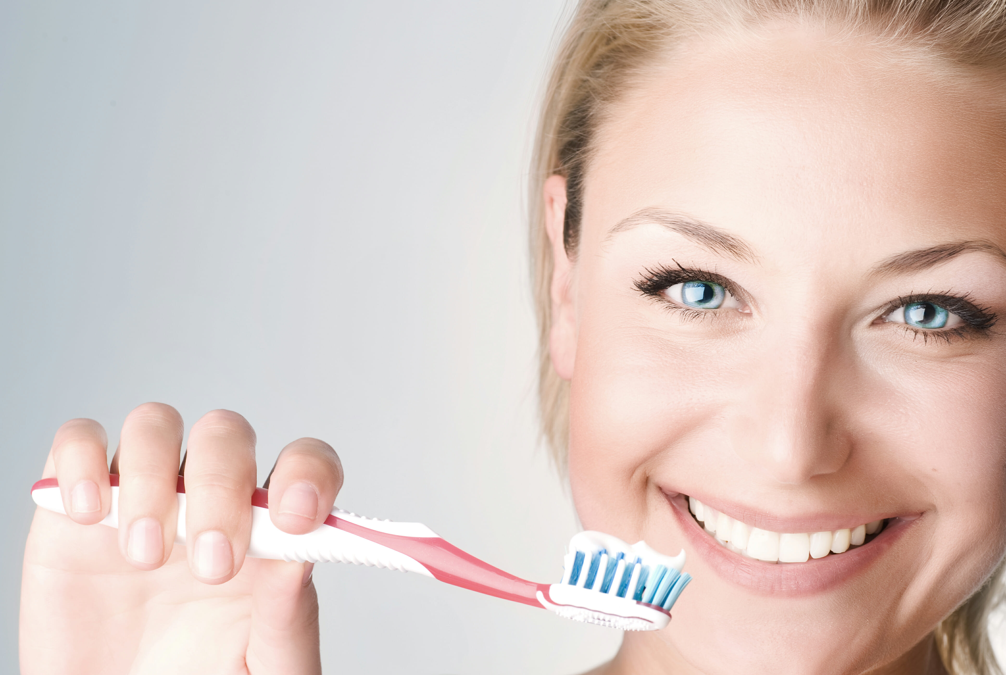 Happy Young Woman Brushing Her Teeth