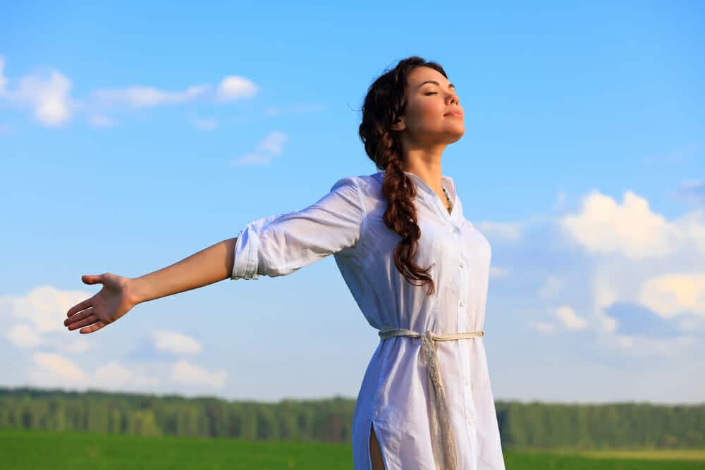 Young happy woman in green field