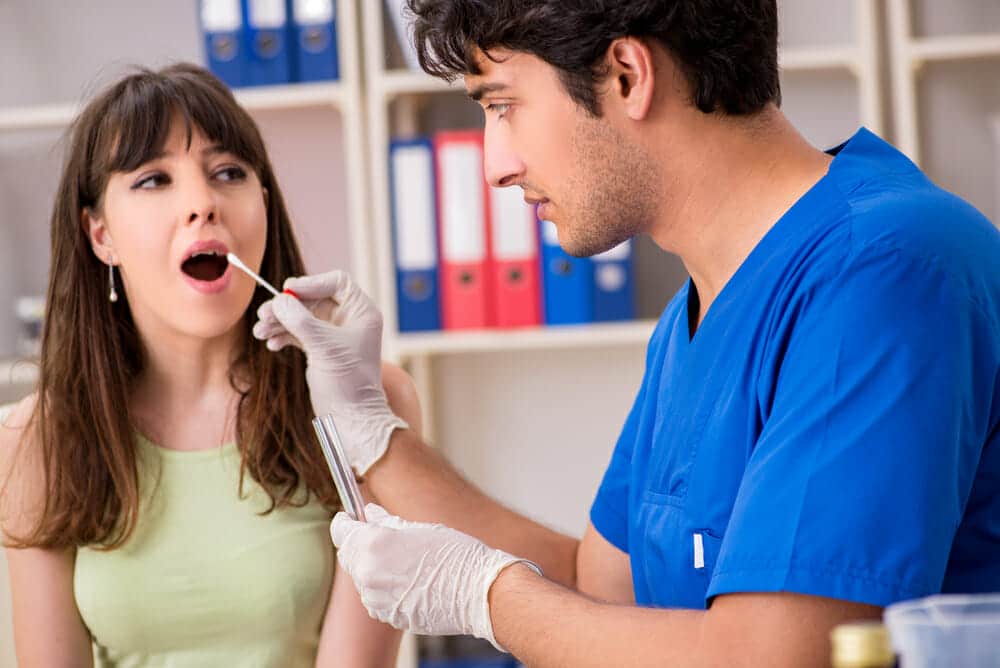 Doctor getting saliva test sample in clinic hospital
