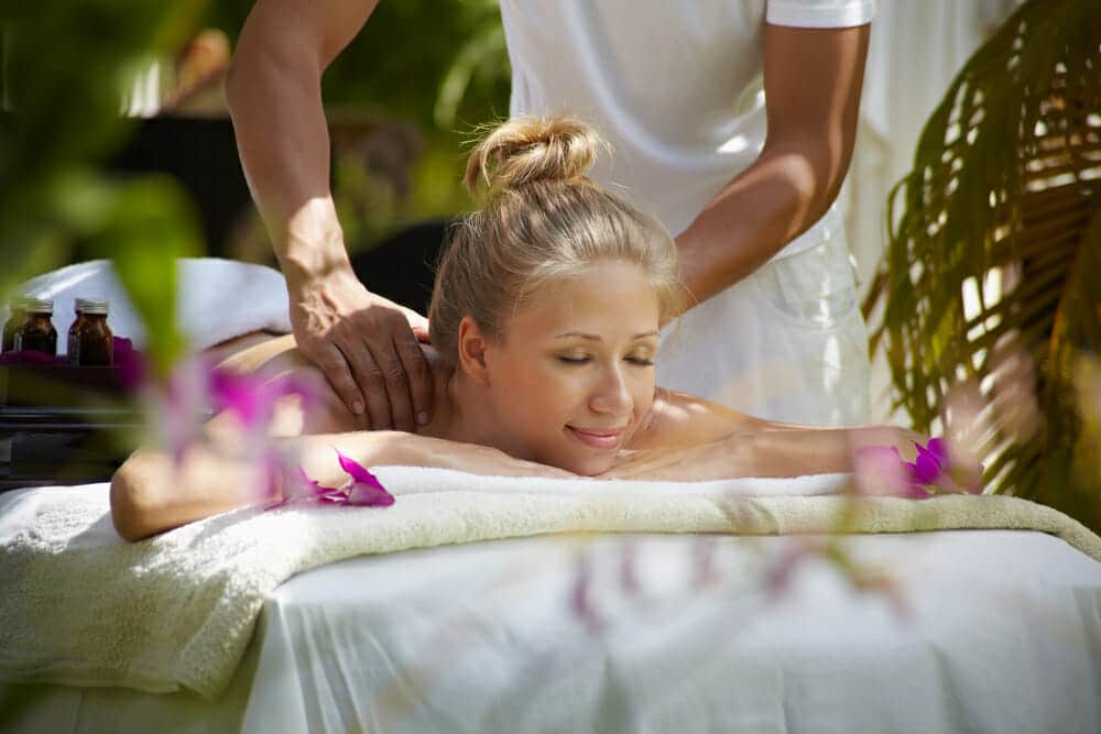 Young beautiful blonde caucasian woman gets massage and beauty treatment in luxury resort. Horizontal shape, side view